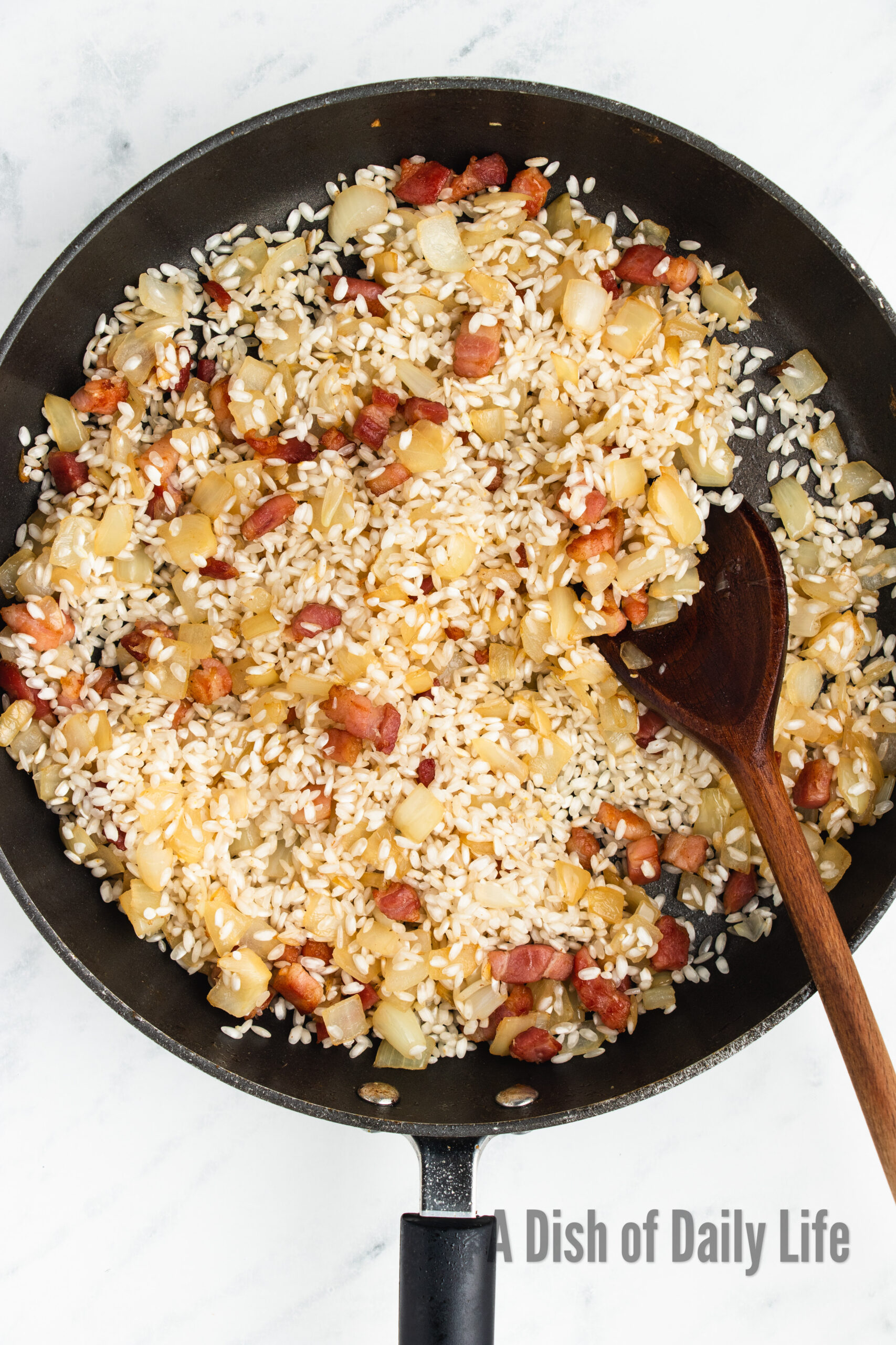 rice and garlic added to onions and bacon