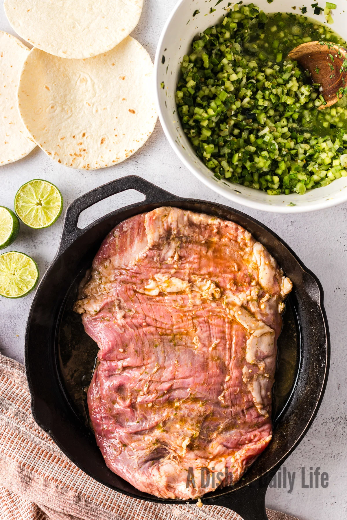 marinated flank steak in skillet ready to cook