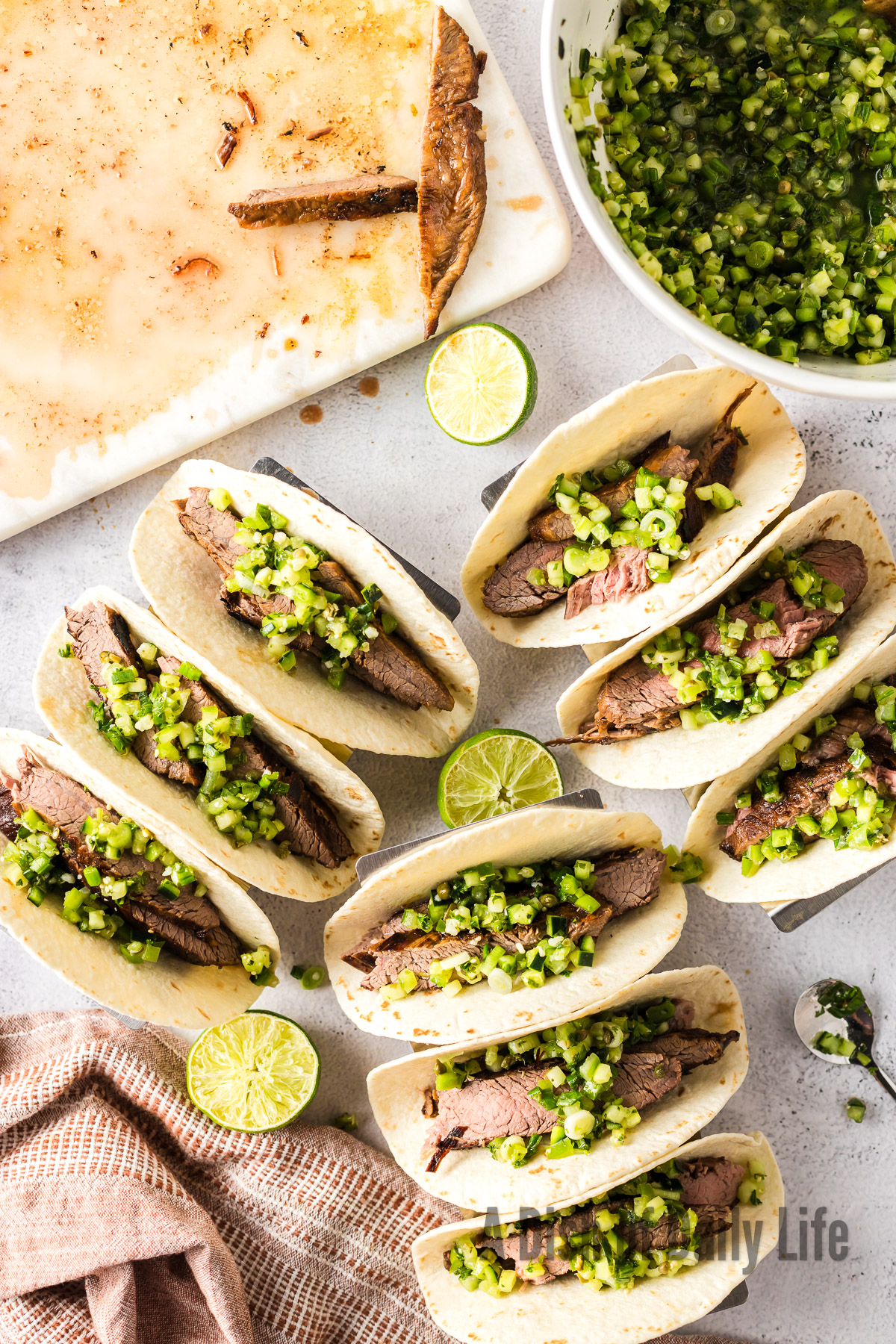 9 tacos laid out on counter with cucumber pico de gallo on top