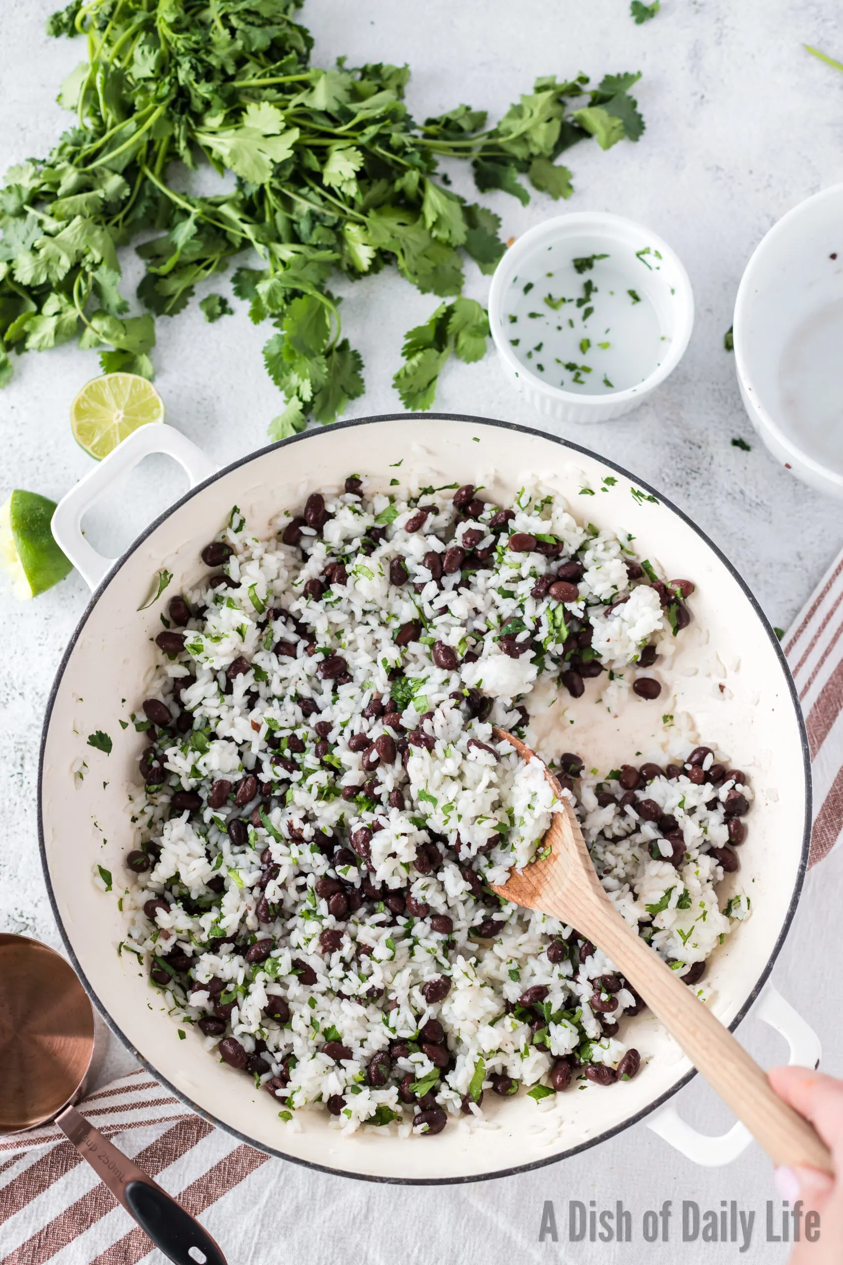 wooden spoon mixing black beans into the rice