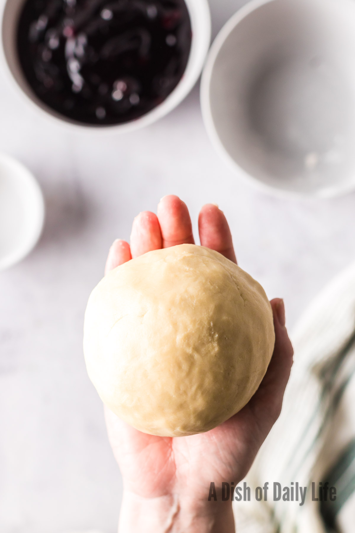 Cookie dough in a large ball in hand