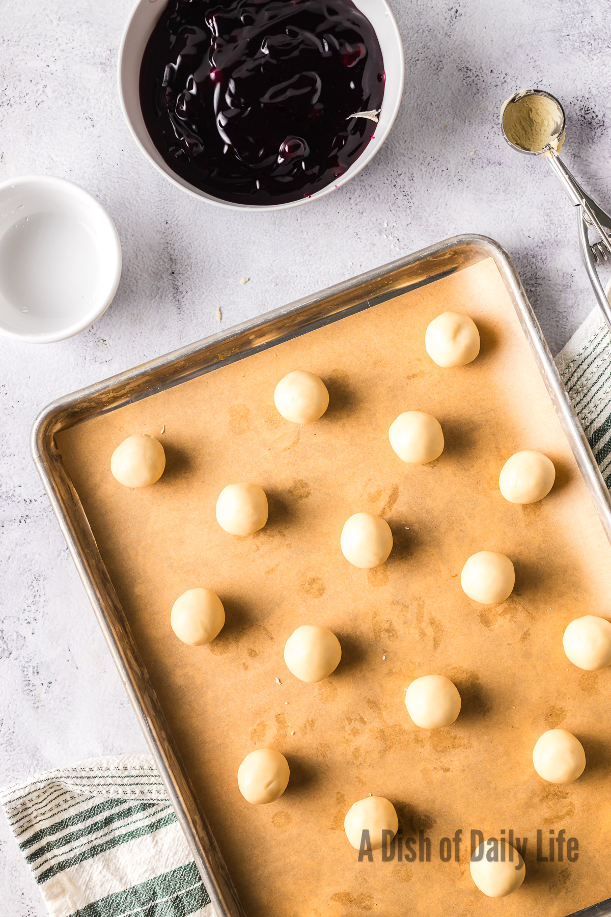 cookie dough rolled out into small balls on cookie sheet