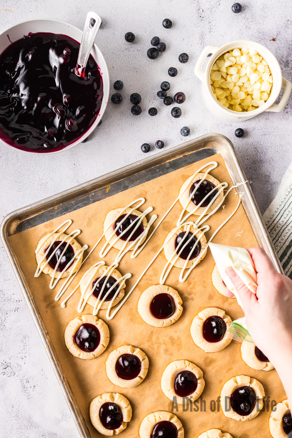 baked cookies with blueberry pie filling and being drizzled with white chocolate