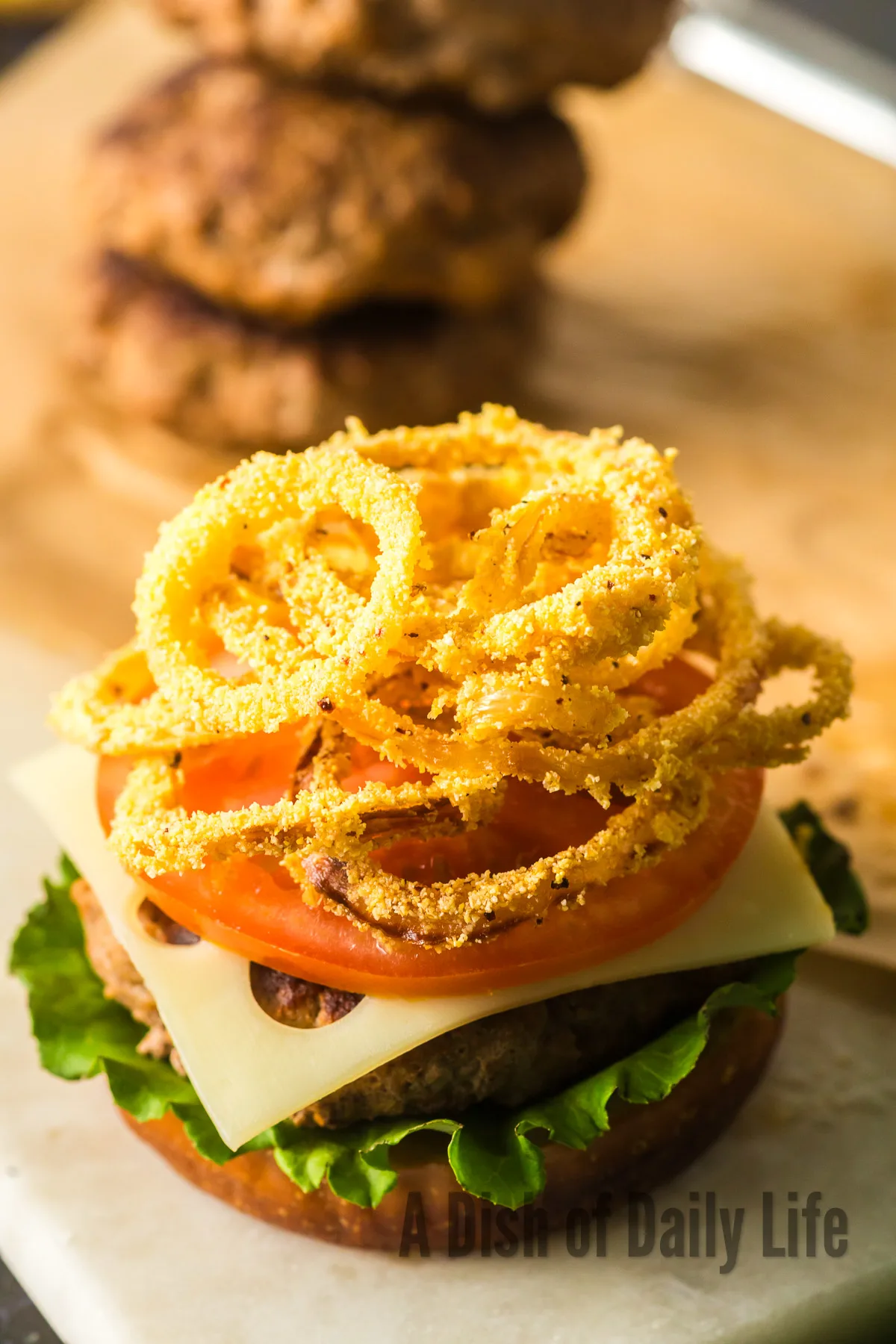 gluten free fried onions on top of a hamburger