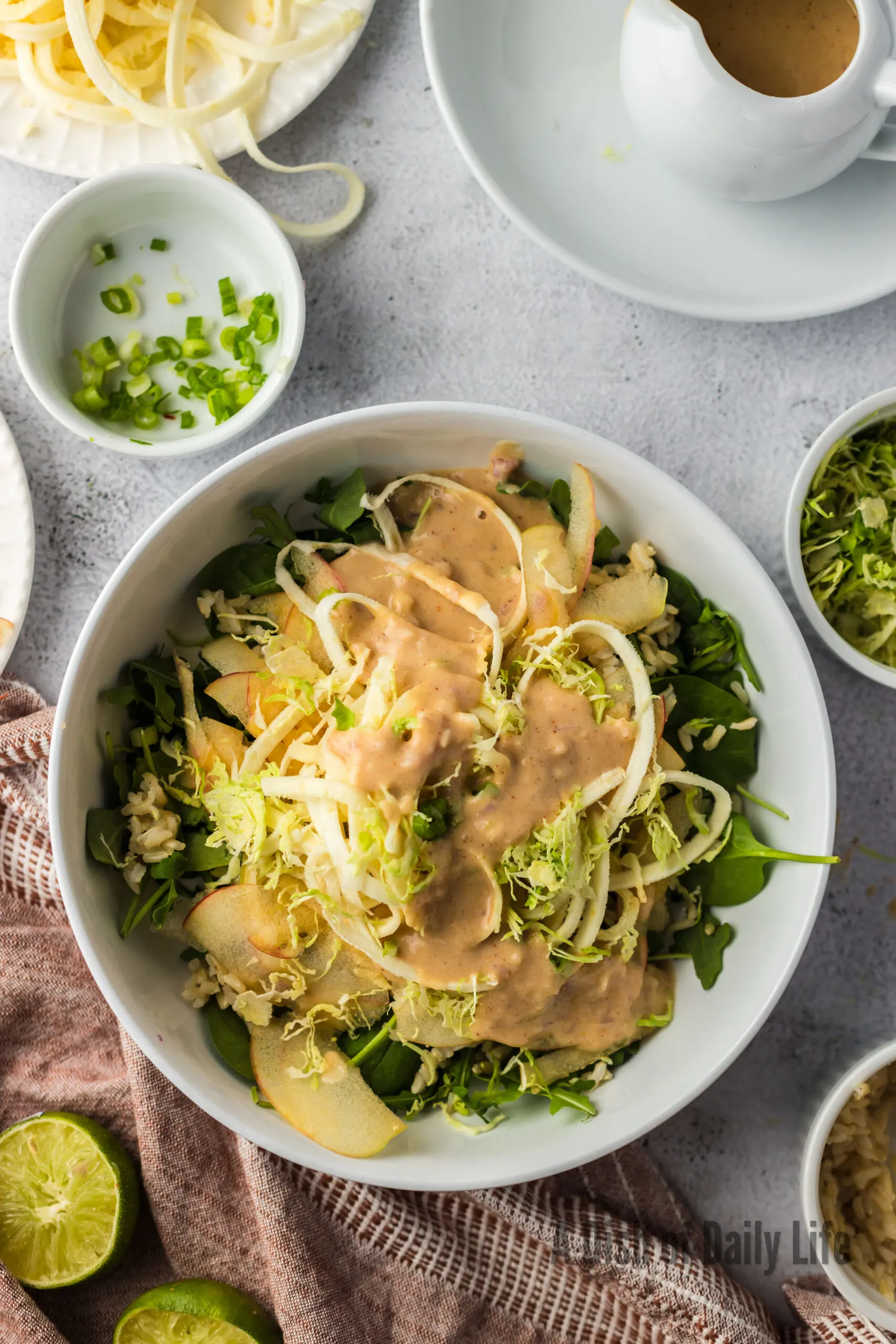 layered salad in a bowl with dressing poured on top