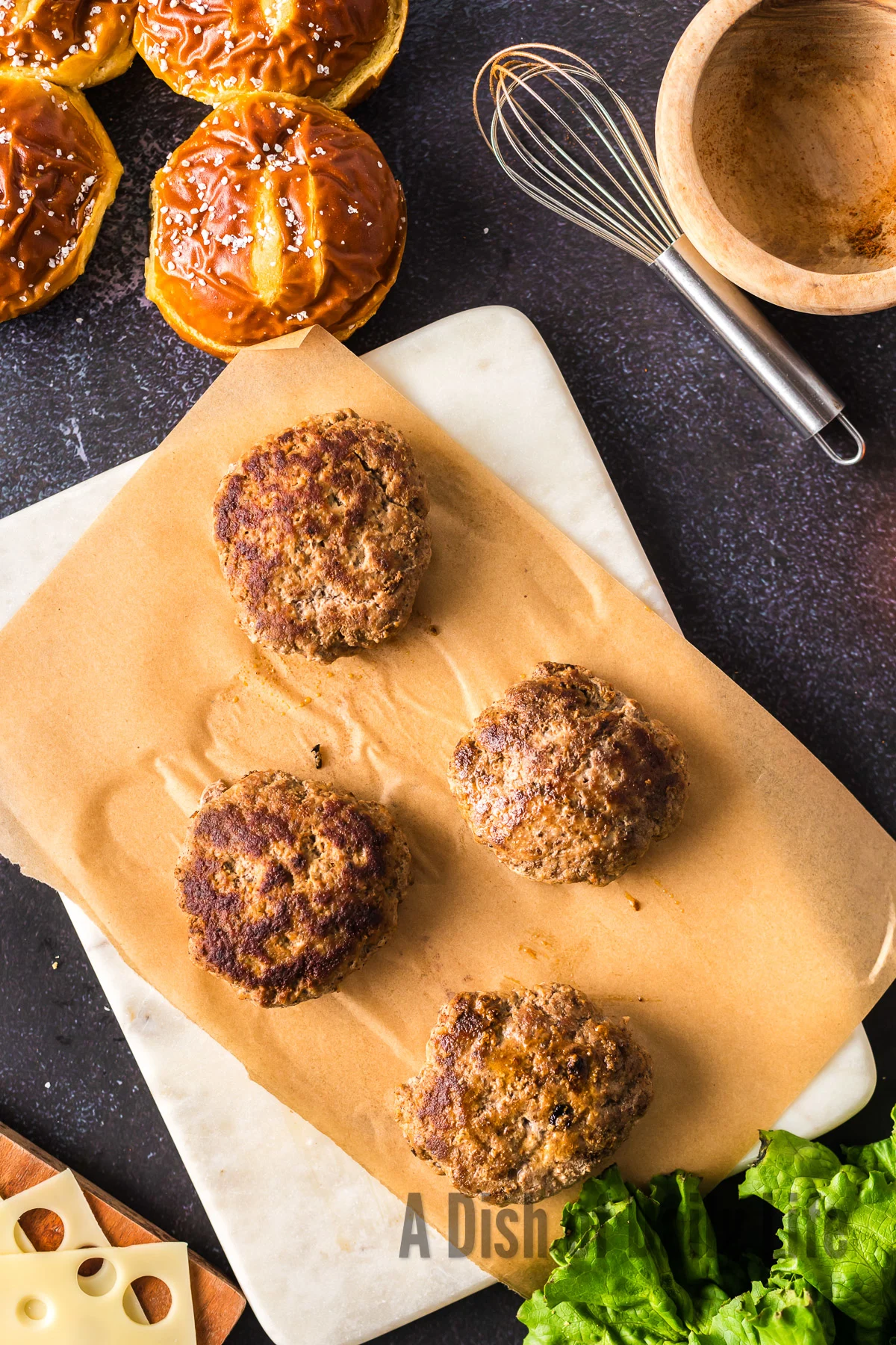 Grilled burger patties laid out on parchment paper