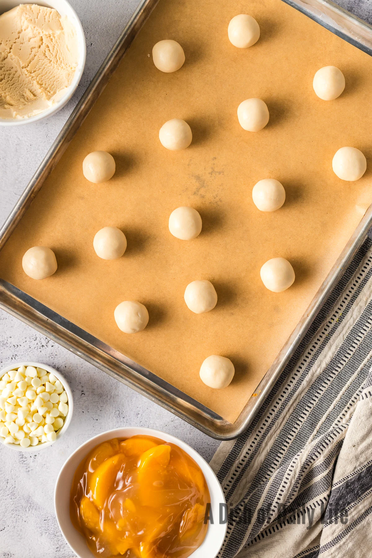15 cookie dough balls laid out on cookie sheet