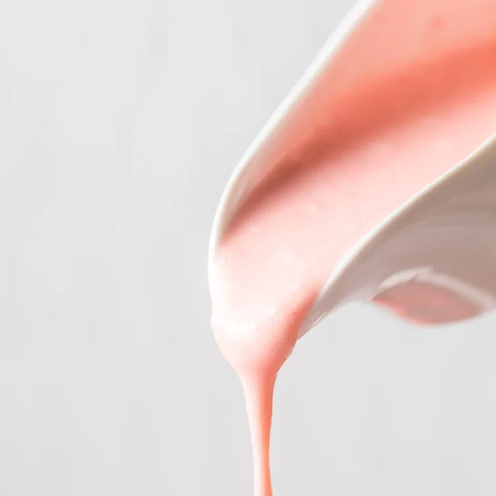 zoomed in image of salad dressing being poured