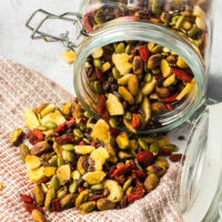 jar of healthy snack mix spilling onto a towel on counter.