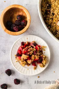 zoomed out image of fruit crumble on plate, ready to eat