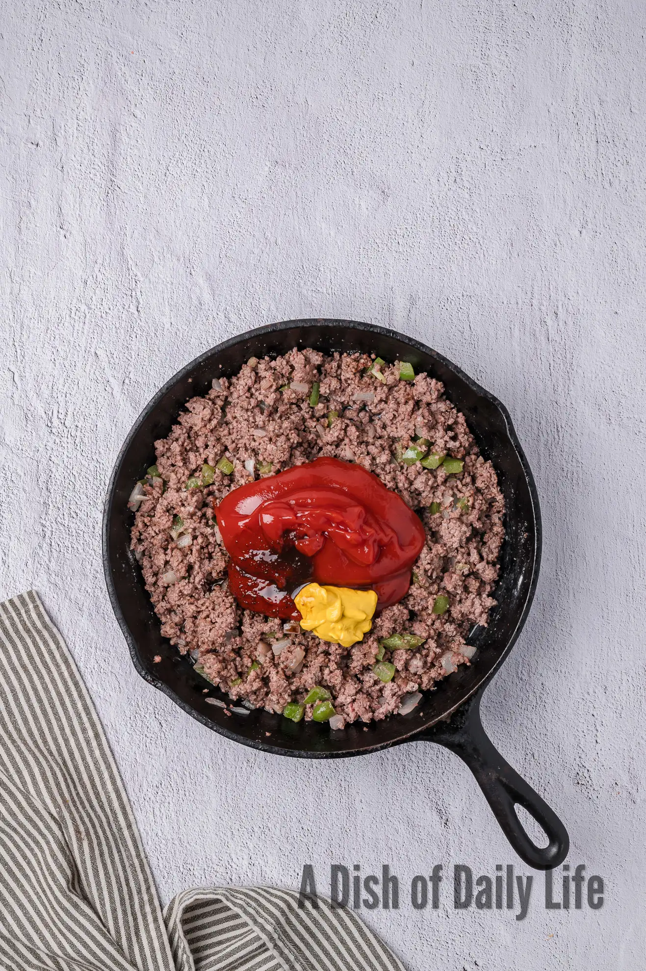 wet ingredients added to seasoned ground beef mixture.