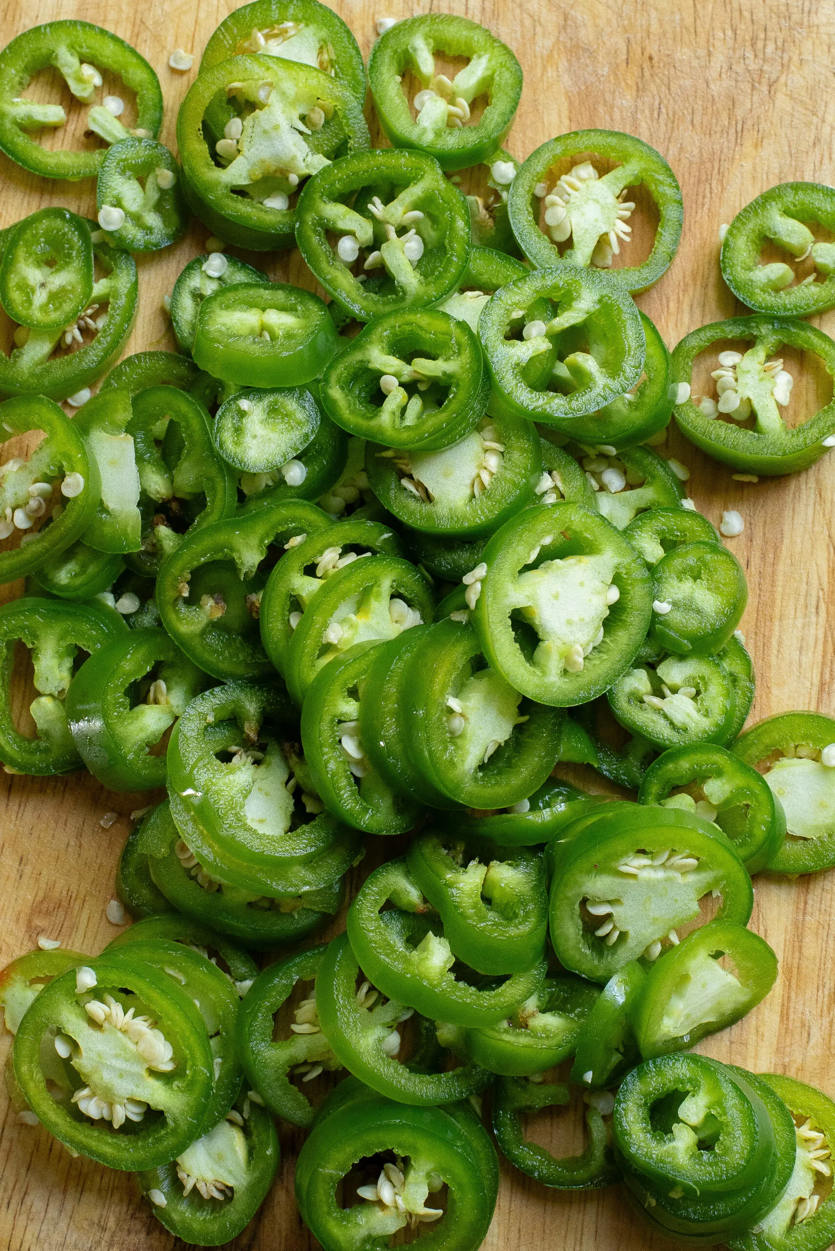 sliced jalapenos on a cutting board.