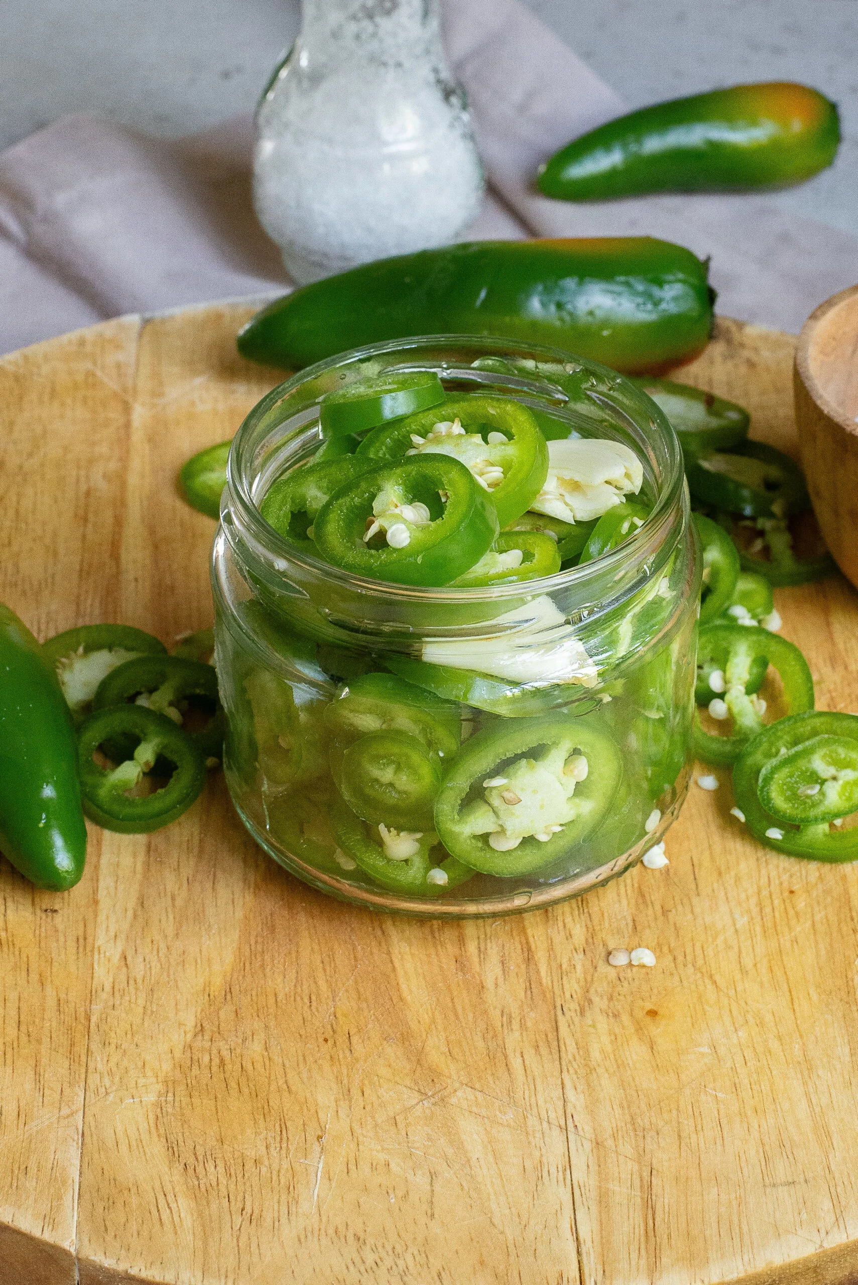 Sliced jalapenos and garlic in a jar.
