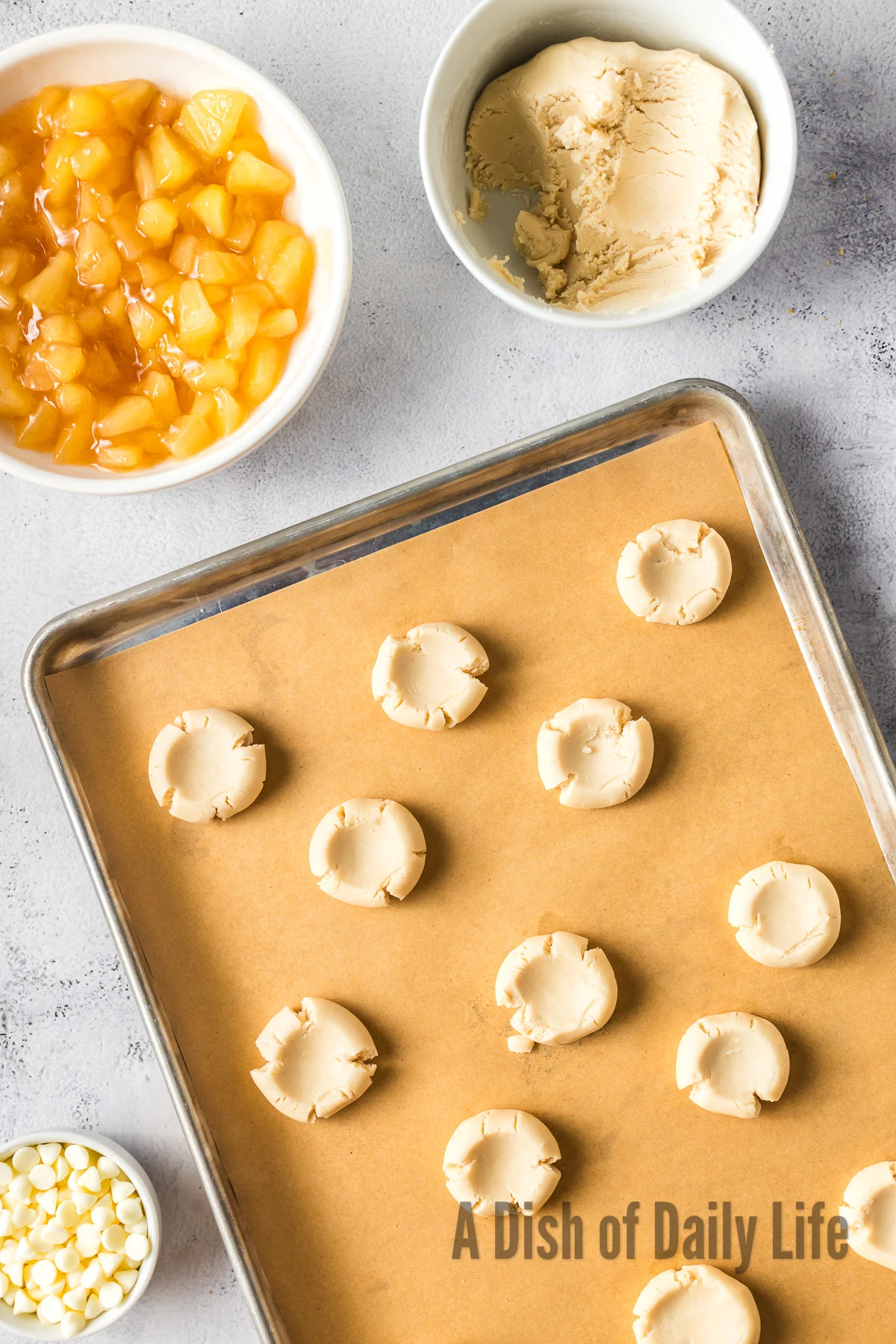 An indent placed in the middle of each cookie on baking sheet.