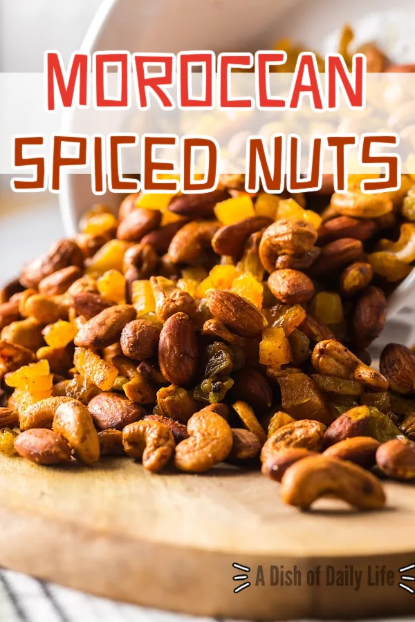 Main image for Moroccan Spiced Nuts recipe. Bowl spilling trail mix onto a cutting board.