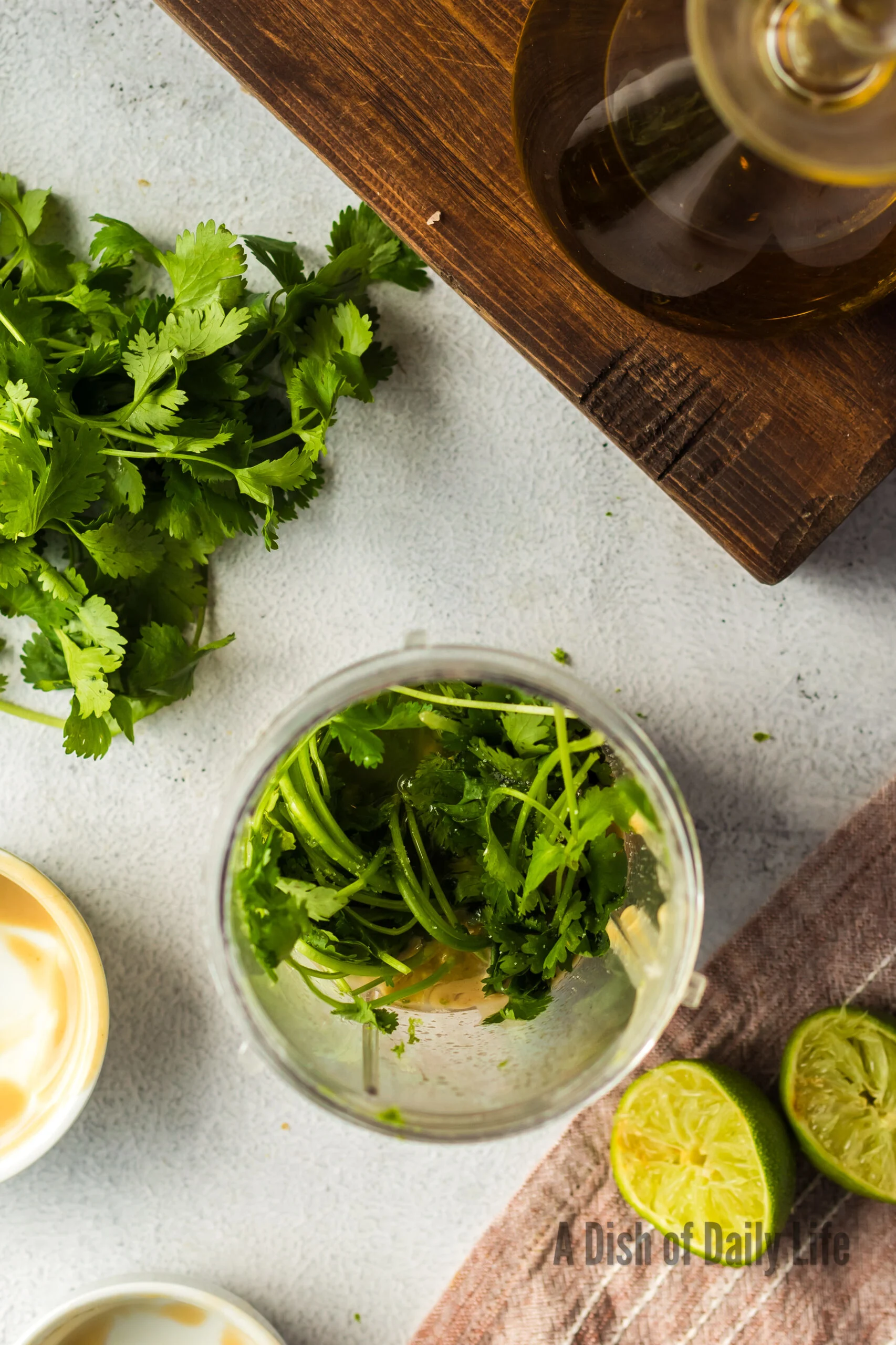 Tahini, lime juice, cilantro, sea salt, maple syrup, lime zest and olive oil in a food processor, unmixed.