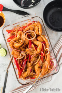 chicken, peppers and onions in casserole dish.